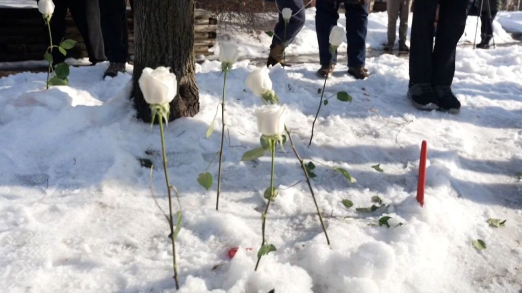 Residents place flowers at scene where woman was shot by ICE